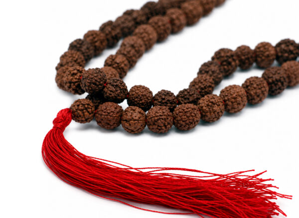 Różaniec „Rudraksha” – zbliżenie na żłobione koraliki i czerwony chwost
